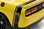 Close-Up of a yellow Dodge Challenger with a black side & trunk stripe, shown from a rear three-quarter angle.