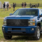 Deep blue Silverado HD with a Liberty or Death grille, parked beside a Revolutionary War reenactment field.