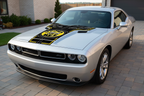 Dodge Challenger with SUPER BEE 392 hood graphics in a bright outdoor performance setting