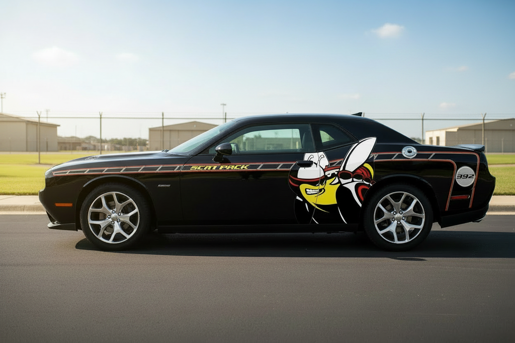 Black Dodge Challenger with Rumble Bee side stripe graphics on a sunny military base roadway