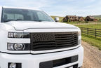  White Chevy Silverado 2500HD with a satin-black Wavy Flag grille parked at a ranch.